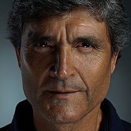 A man with grey hair and a blue shirt.