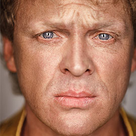 A man with blue eyes stares into the camera.